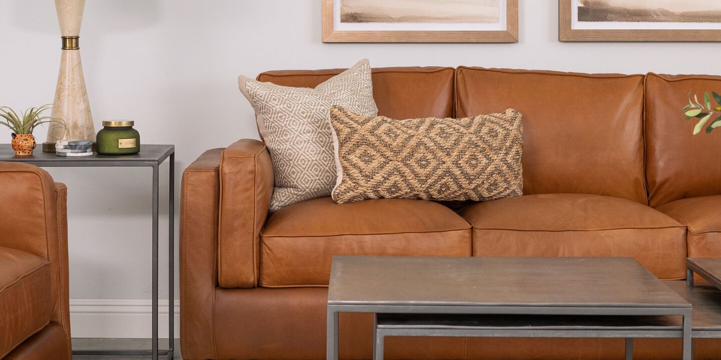 Living room with brown leather sofa, chair, and a metal coffee table with matching side table