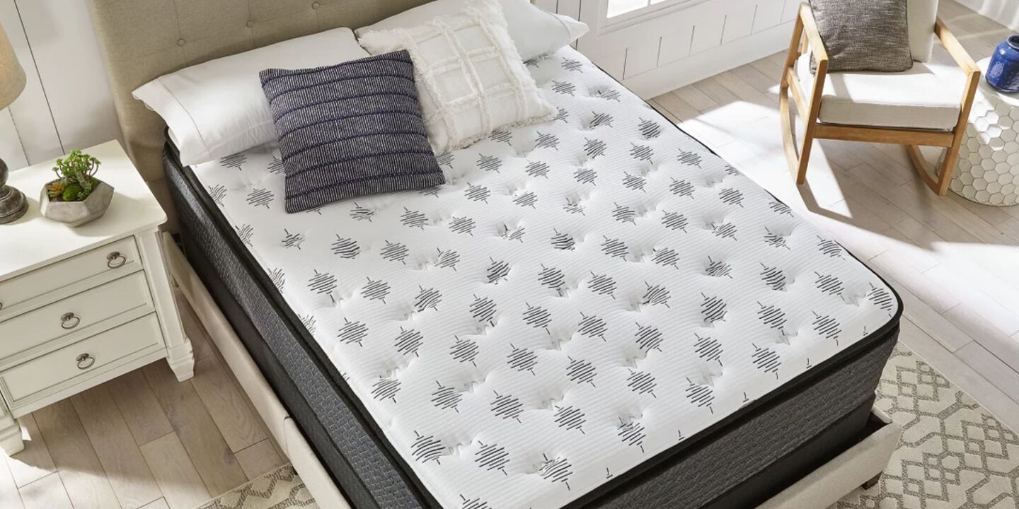 Aerial view of a white and grey mattress on top of a beige bedframe