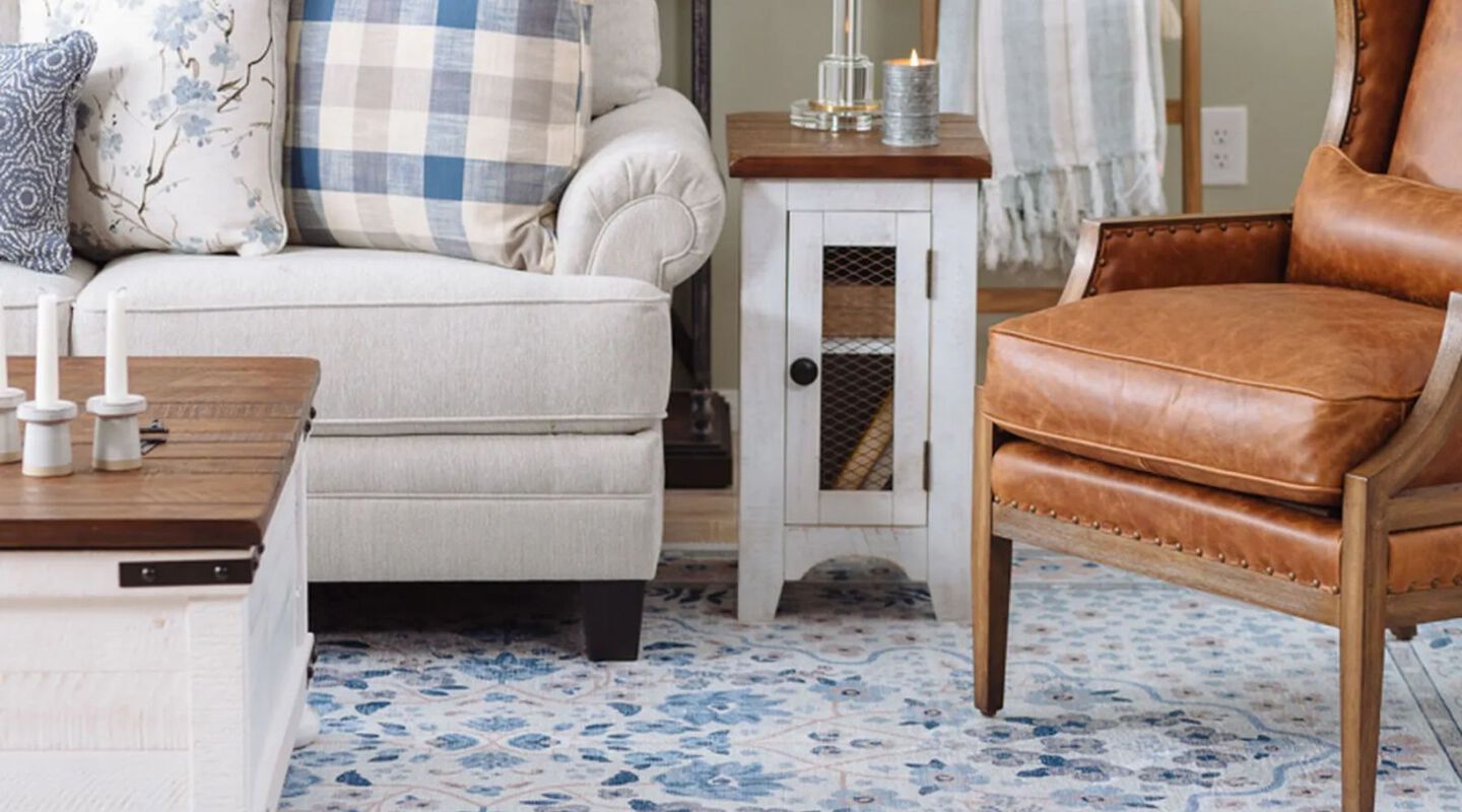 Living room with beige couch, brown chair, and white and brown side table