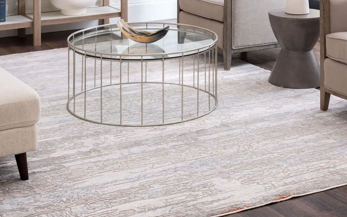 living room setting with glass coffee table and a light beige and grey rug