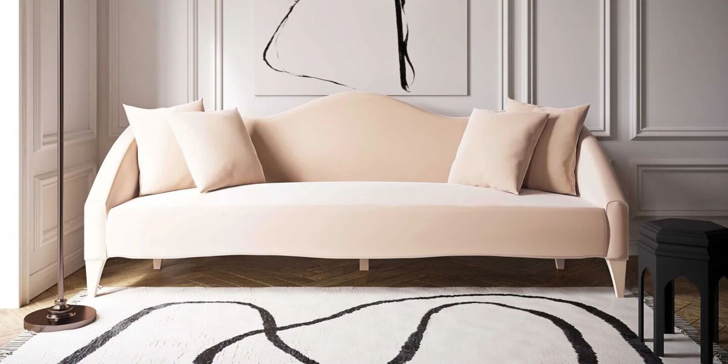 Light peach colored couch sitting on top of a black and white rug