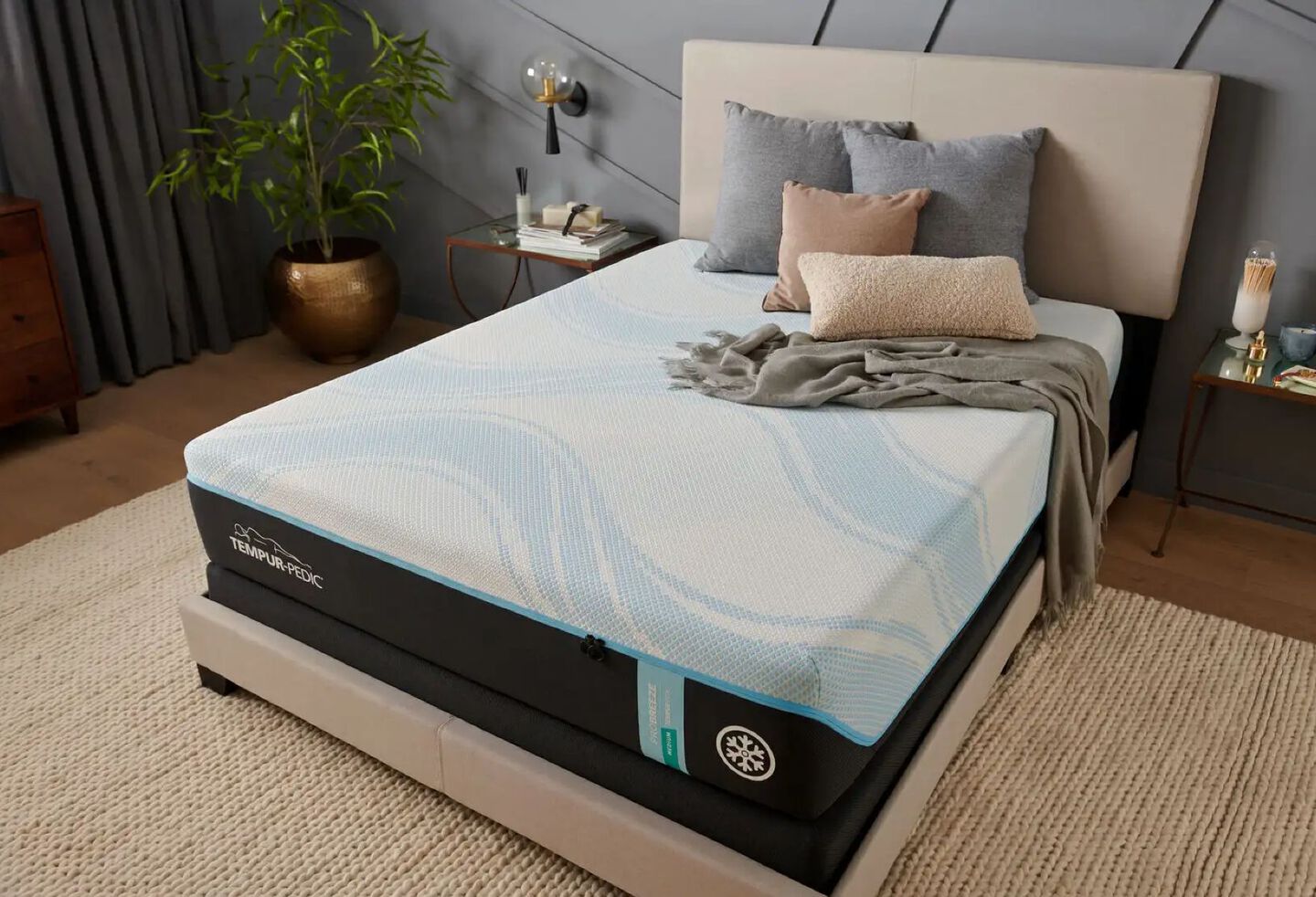 Tempur-pedic mattress atop a beige bedframe in a bedroom