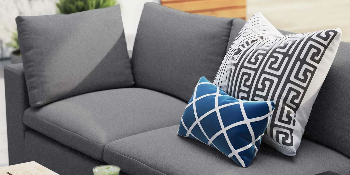 Grey outdoor sofa with two pillows on top