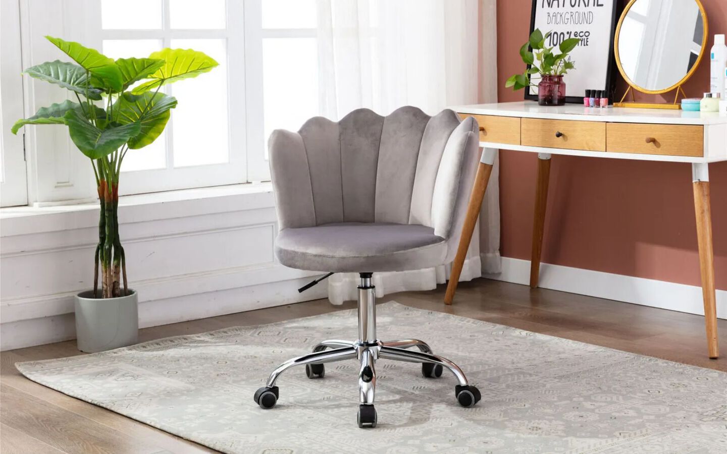 Room with white and gold vanity and light grey velvet swivel chair