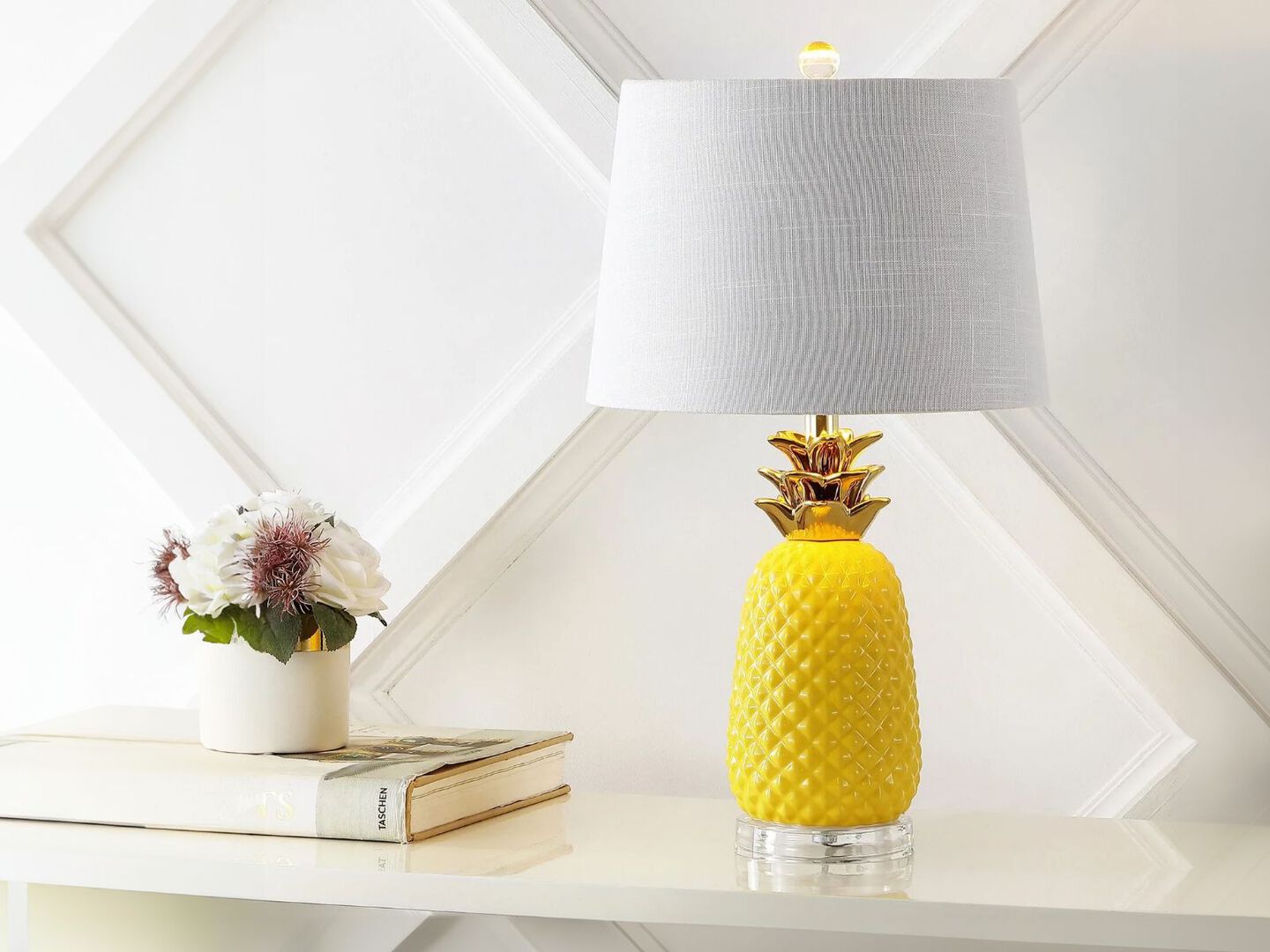 Yellow and gold pineapple shaped table lamp sitting on a white table