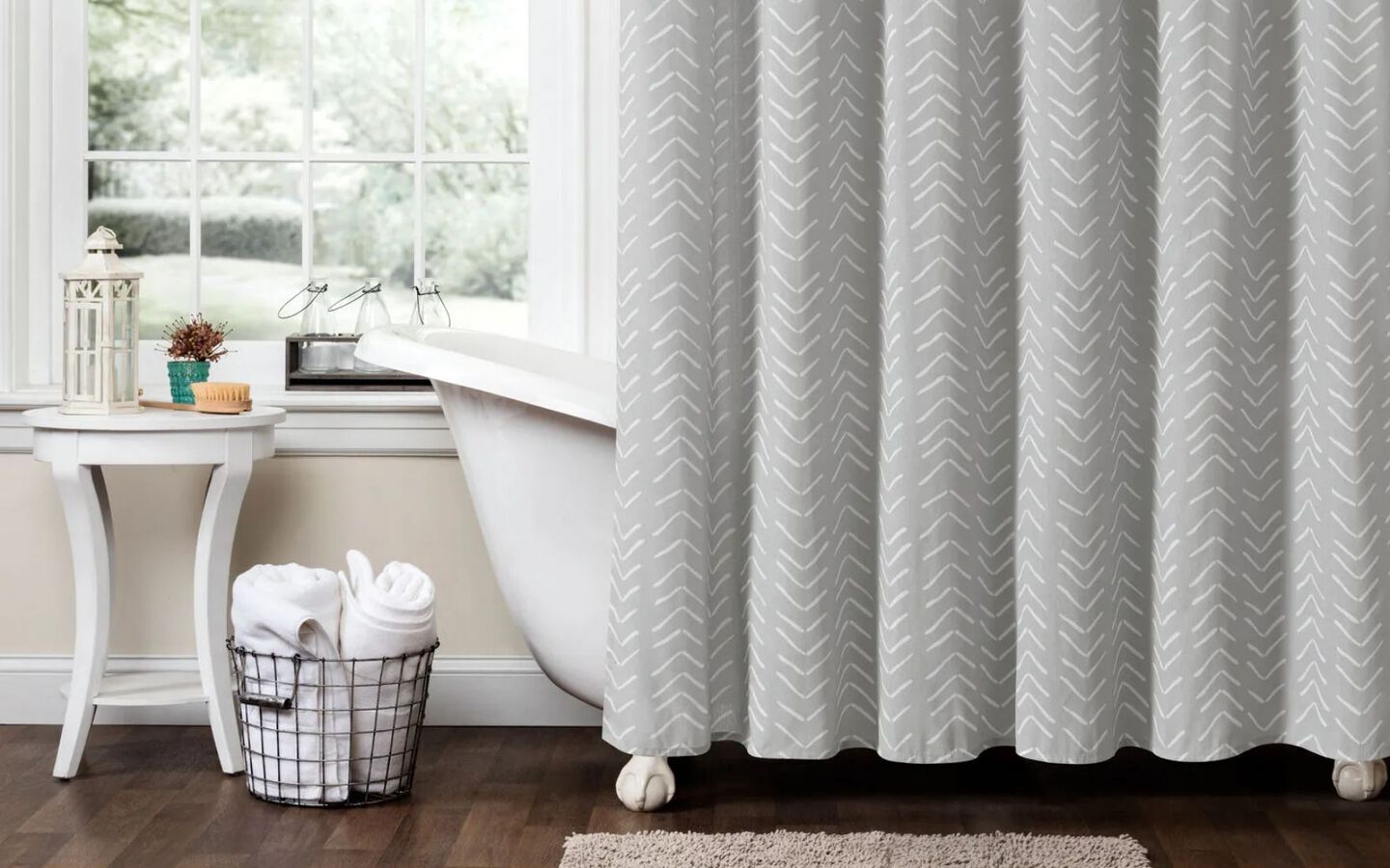 Bathroom with white bathtub with grey shower curtain