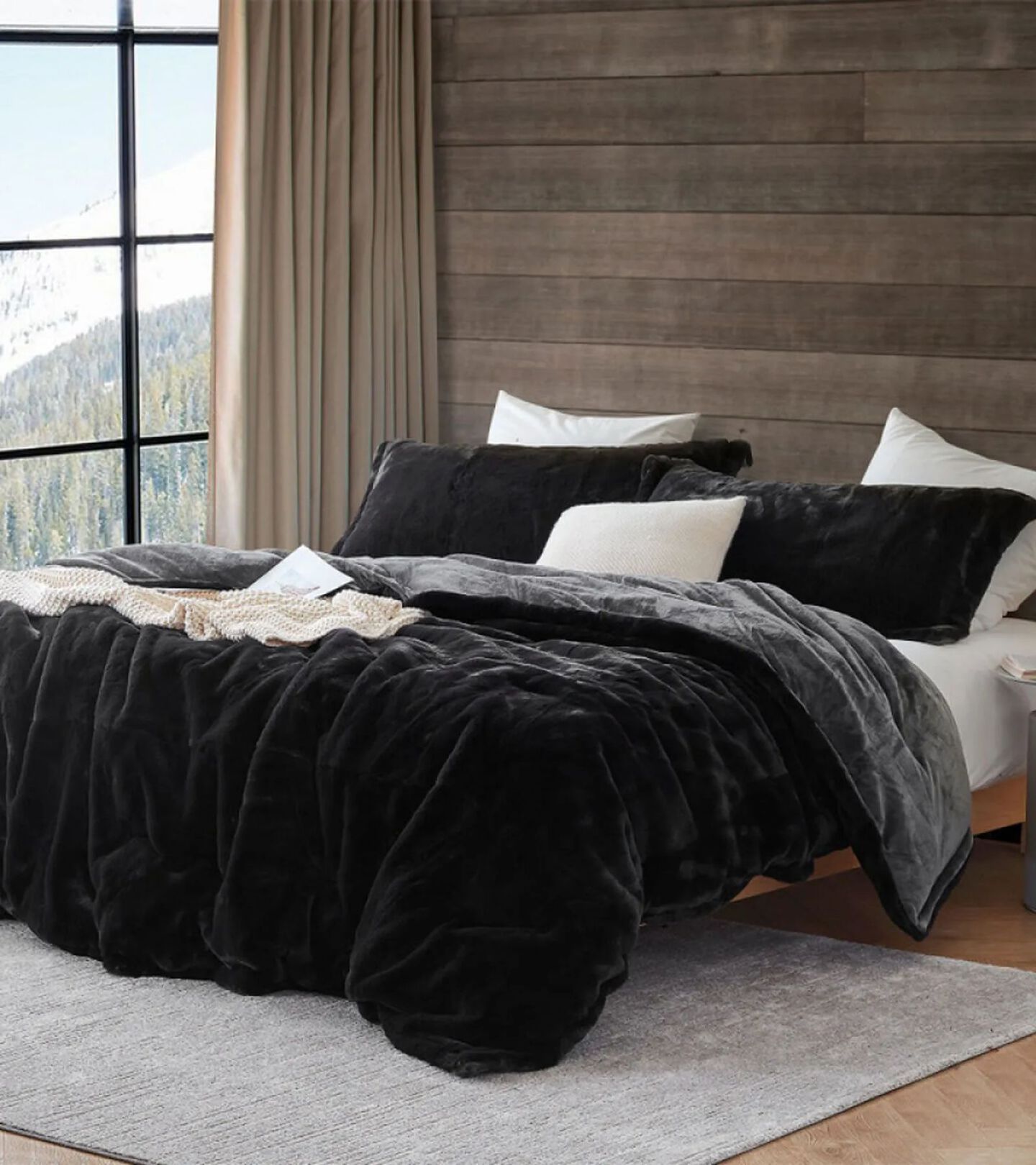 bed with black comforter and white and black pillows