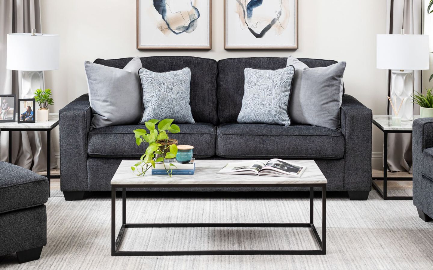 Living room with navy blue couch and white and black coffee table with two matching tables