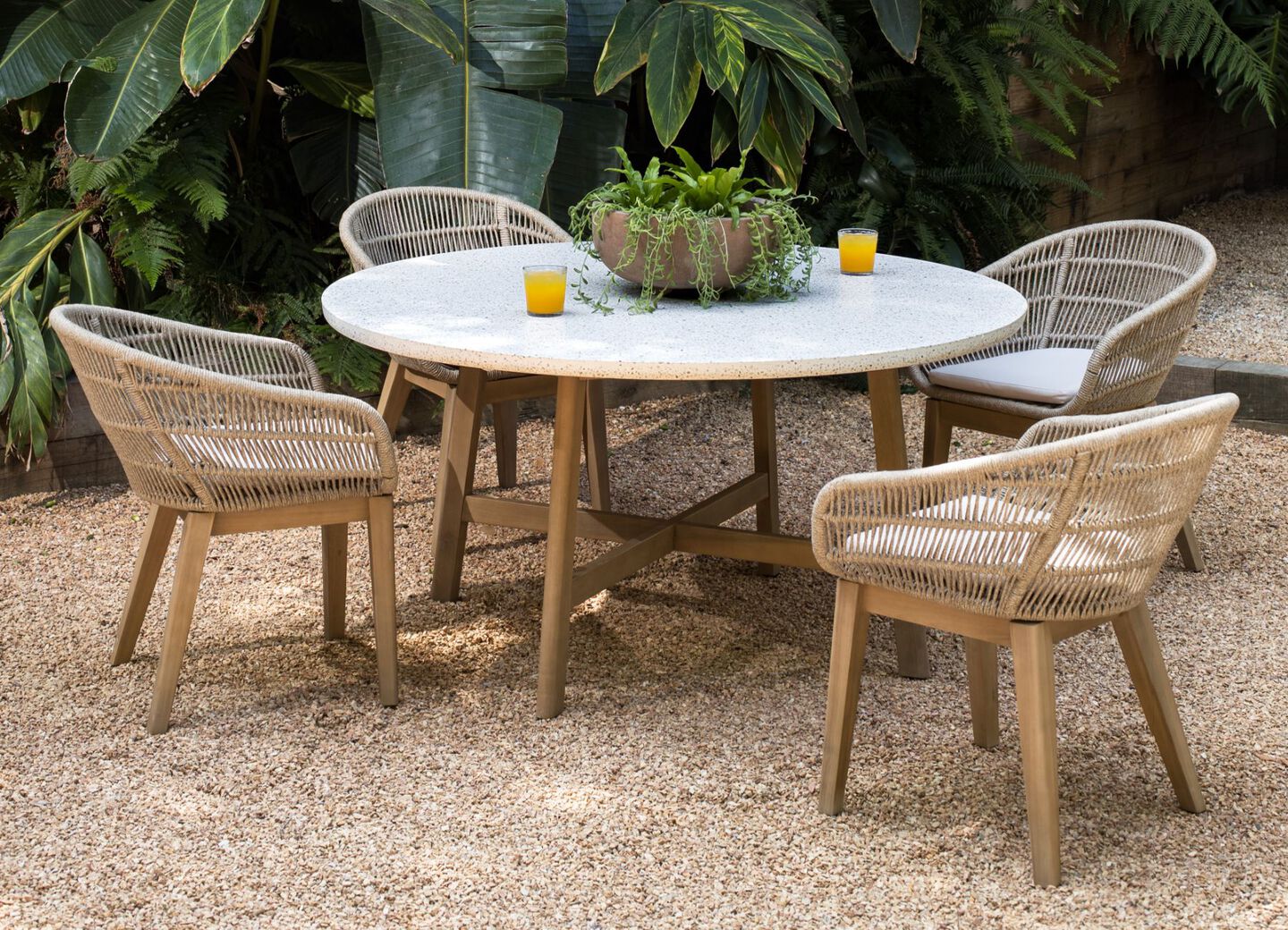 White marble patio table with light brown features and matching wooden chairs.