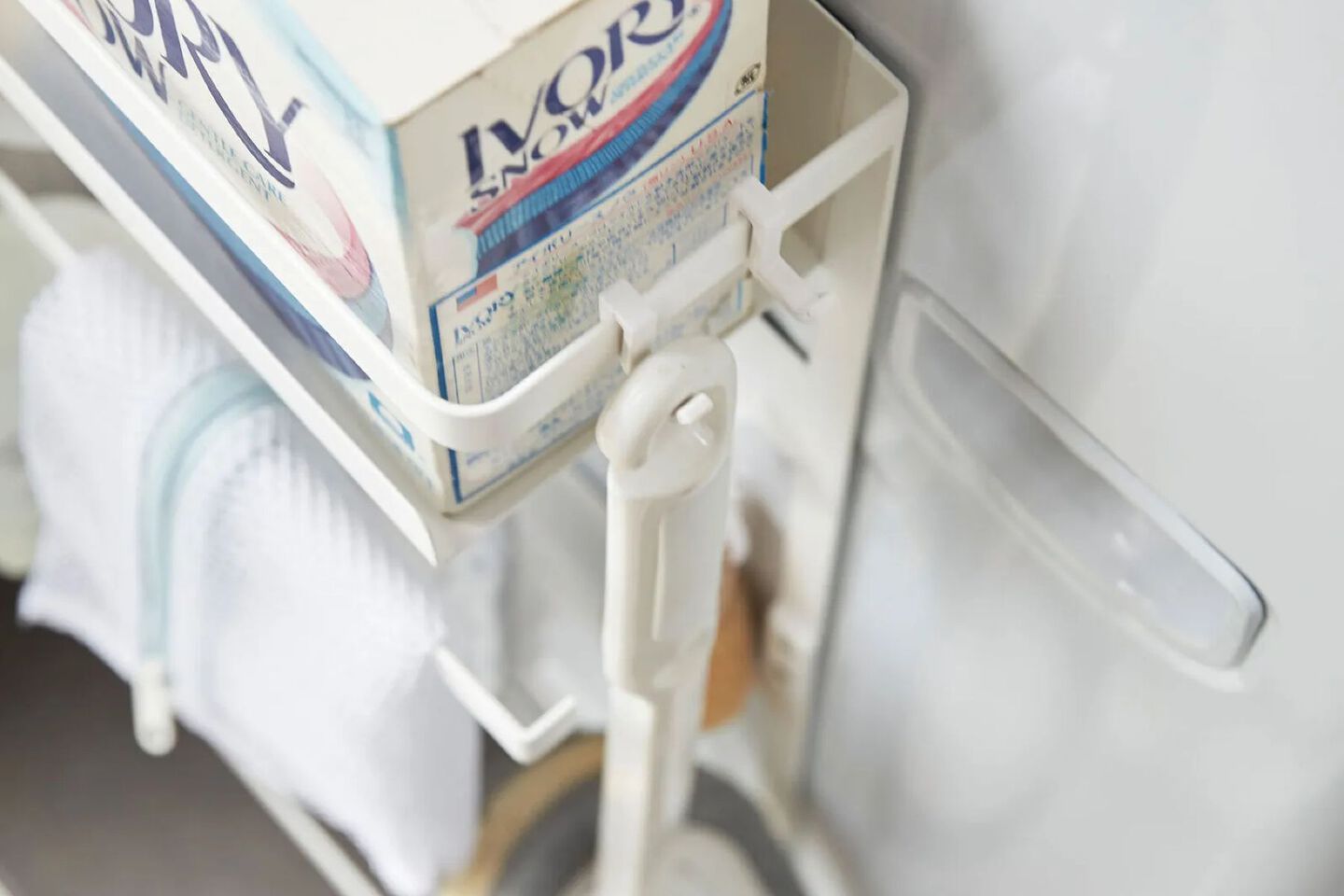 Aerial image of a three-tiered shelf holding cleaning supplies and towels