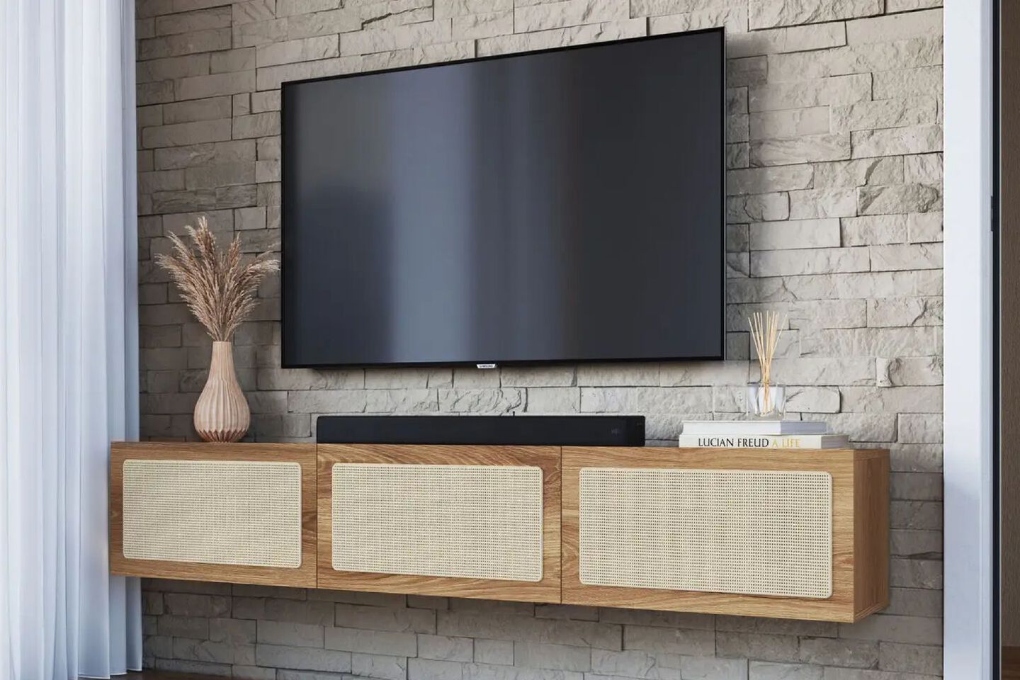Wooden floating media console hanging on brick wall with a tv mounted above