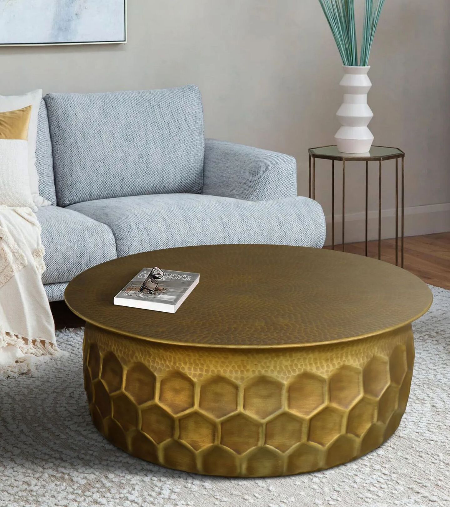 living room setting with hammered brass coffee table and grey couch