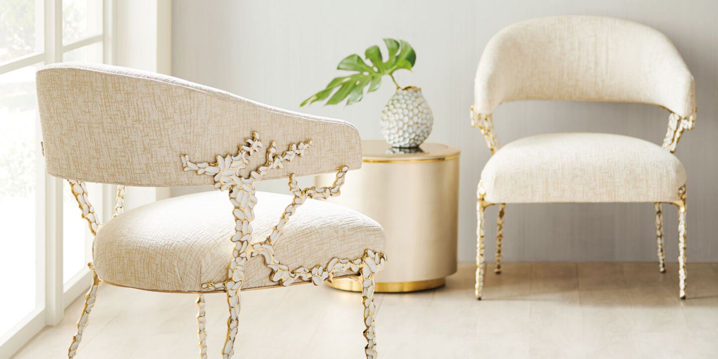two light cream-colored chairs with gold and white detailing two light cream-colored chairs with gold and white detailing