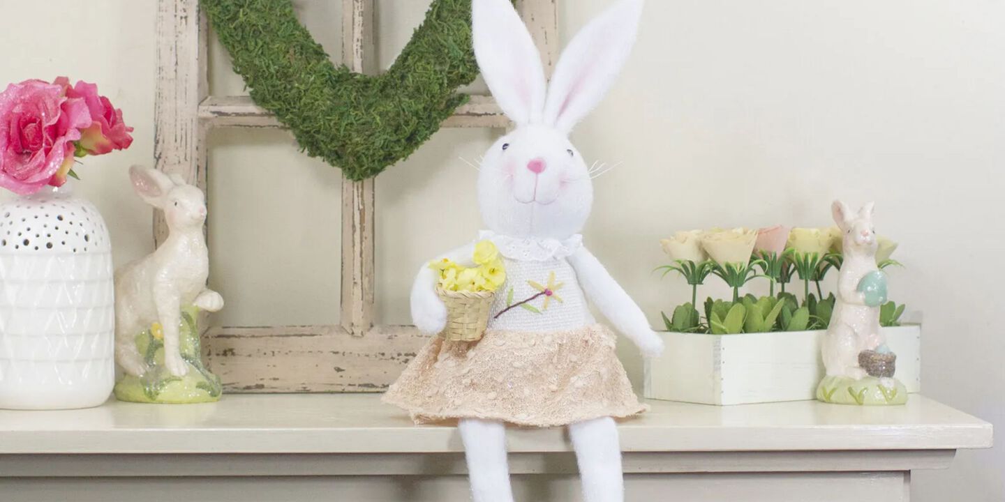 Shelf with white and pink bunny and several other Easter-themed decorations sitting on it