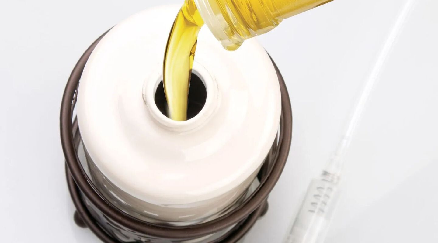 Aerial closeup of a white porcelain bottle being filled with yellow soap